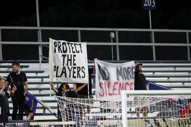 Fans hold signs during the first half of a NWSL soccer match between Racing Louisville FC and the North Carolina Courage at WakeMed Soccer Park. Reuters