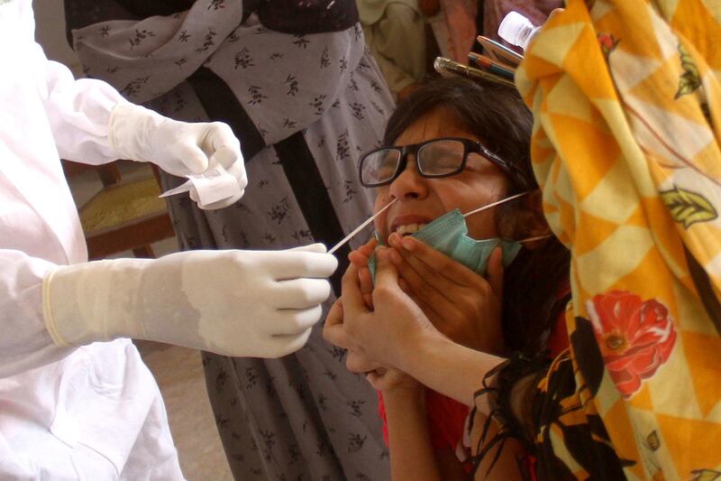 A health official takes a nasal swab sample for a Covid-19 test in Hyderabad, Pakistan. EPA