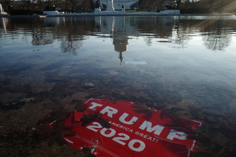epa08925154 A 'Trump 2020' placard is submerged as the US Capitol Dome reflection is seen on the water of the US Capitol reflecting pool, in Washington, DC, USA, 07 January 2021, the morning after various groups of President Trump's supporters broke into the US Capitol and rioted as Congress met to certify the results of the 2020 US Presidential election.  EPA/GAMAL DIAB