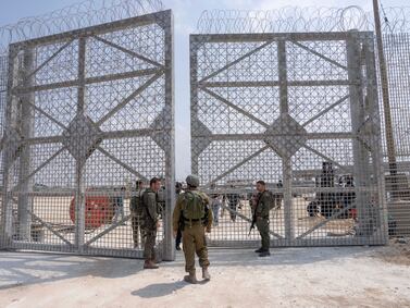 Israeli soldiers gather near a gate to walks through an inspection area for trucks carrying humanitarian aid supplies bound for the Gaza Strip, on the Israeli side of the Erez crossing into Gaza on Wednesday. AP