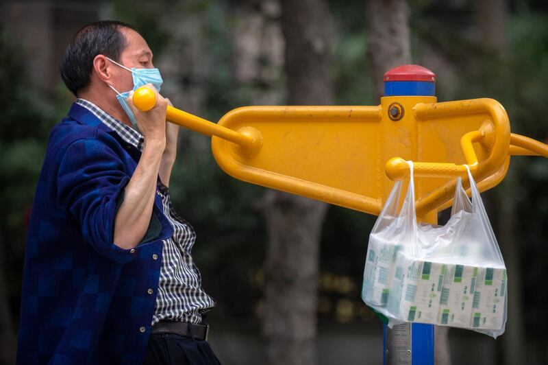 A man wearing a face mask uses exercise equipment at a public park in Beijing. AP Photo