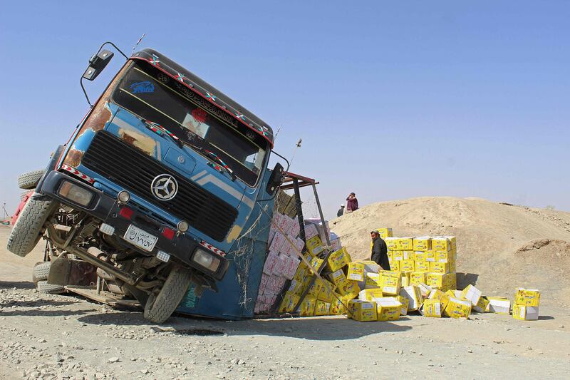 An Afghan driver stands amid boxes of dry food next to his damaged truck at the site of an accident near the Pakistan-Afghanistan border crossing point in Chaman. AFP