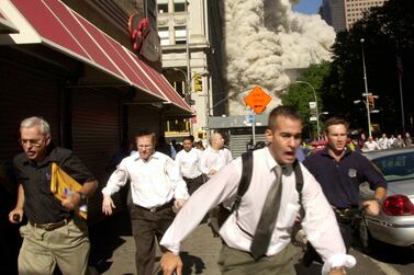 FILE - In this Tuesday, Sept.  11, 2001 file photo, People run from the collapse of one of the twin towers of New York's World Trade Center.  (AP Photo / Suzanne Plunkett, File)