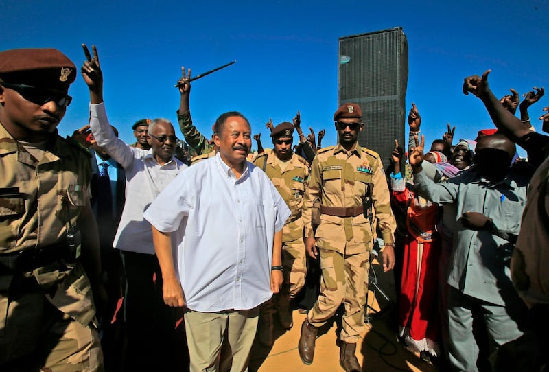 Sudan's Prime Minister Abdalla Hamdok (C) is greeted by supporters upon arriving in El-Fasher, the capital of the North Darfur state, on November 04, 2019. Hamdok's one-day visit was his first as prime minister to the devastated region, where a conflict that erupted in 2003 has left hundreds of thousands dead and millions displaced. He said his government was working toward bringing peace to war-torn Darfur as he met hundreds of victims of the conflict who demanded swift justice. / AFP / ASHRAF SHAZLY
