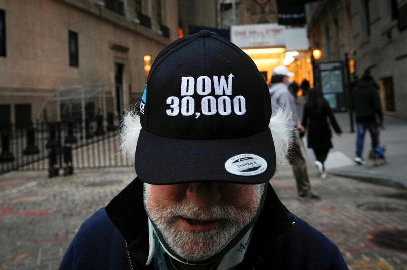 Trader Peter Tuchman wears a DOW 30,000 hat as he greets friends outside the New York Stock Exchange in New York, on November 24, 2020. Reuters