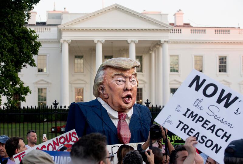 epaselect epa06897413 An oversized puppet depicting the image of US President Donald J. Trump that is labeled 'Putin's Puppet' is among a crowd of hundreds of people participating in a national vigil 'to demand democracy' and to 'confront corruption', on Pennsylvania Avenue outside the White House in Washington, DC, USA, 18 July 2018. Vigils were organized at various locations throughout the USA to voice criticism of President Trump for his handling of a news conference with President of Russia Vladimir Putin in Helsinki, 16 July. Critics accuse Trump of failing to stand up to the Russian leader and betraying US intelligence agencies by publicly casting doubt on their findings.  EPA/MICHAEL REYNOLDS