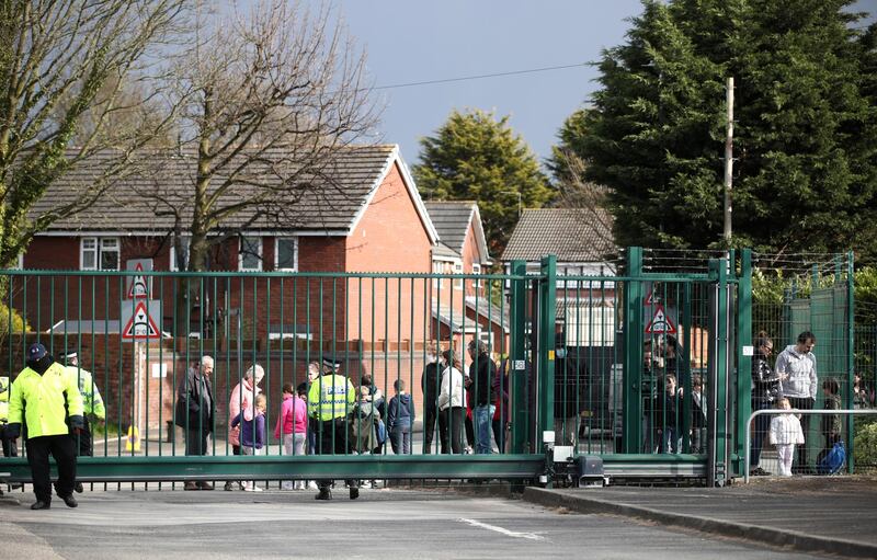 Members of the public outside the gates watch the start of the Grand National at Aintree Racecourse in Liverpool. Getty