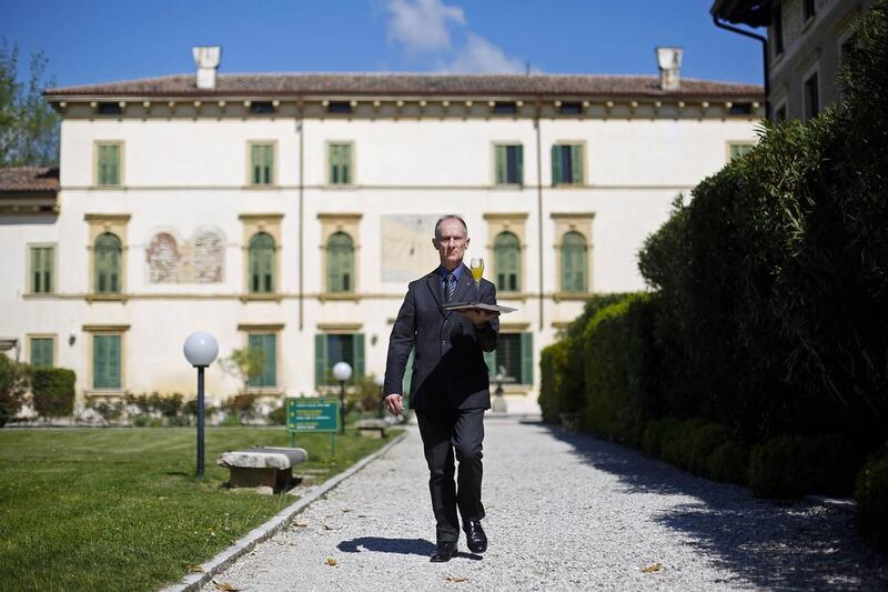 Maurizio Tagliavia walks with a drink at the Villa Del Quar. Max Rossi / Reuters