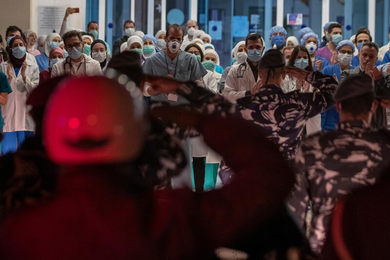 Lebanese policemen salute government-run Rafik Hariri University Hospital workers, where most of the Lebanese coronavirus cases are treated, in support of Lebanese National Health Service workers who are treating coronavirus victims, as part of a nationwide salute to the doctors, nurses and staff in Beirut. AP Photo