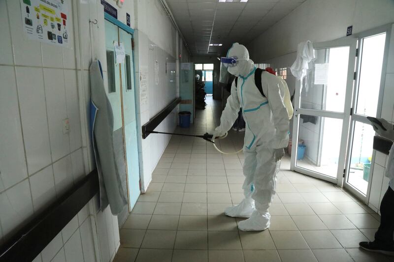 A health worker wearing protective suit and face mask disinfects a hallway of a hospital after a case of Ebola was confirmed in Abidjan, Ivory Coast. Luc Gnago / Reuters