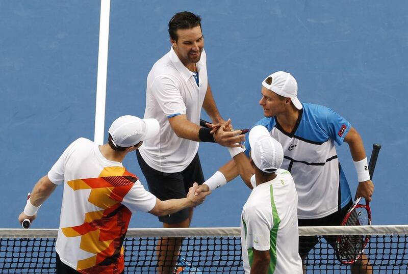 Leyton Hewitt, in blue, and his doubles partner Pat Rafter, to his left, shake hands with opponents Raven Klaasen, green and Eric Butorac, orange, after losing their doubles match on Wednesday.
