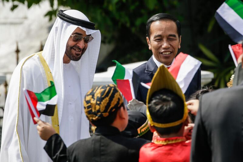 Abu Dhabi's Crown Prince Sheikh Mohammed bin Zayed Al Nahyan, left, and Indonesian President Joko Widodo, right, react as they are greeted by school children upon arrival for their meeting at the presidential palace in Bogor, Indonesia, Wednesday, July 24, 2019. (Mast Irham/Pool Photo via AP)