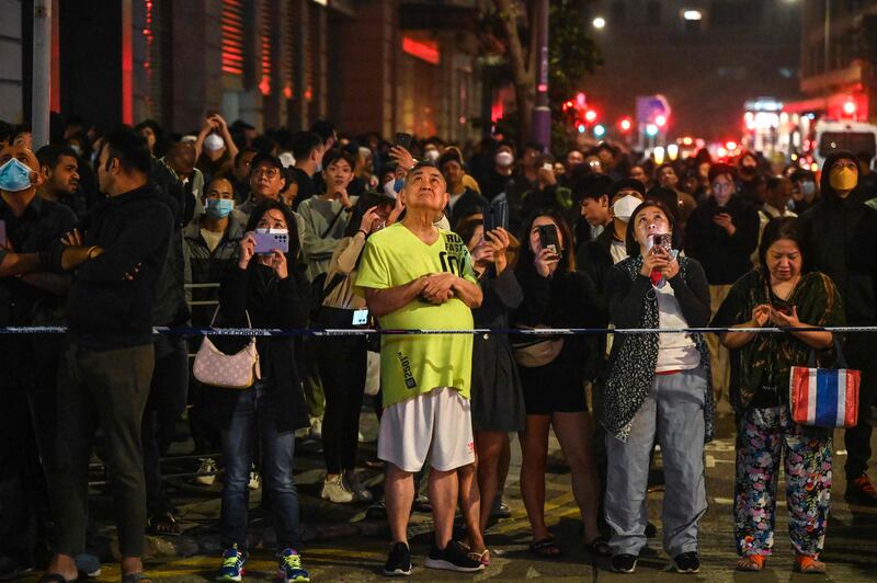 Onlookers gather on the street to watch the operation that involved 250 firefighters and paramedics. AFP