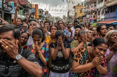 Sri Lankans pray in the street near St Anthony's Shrine a week after the attacks that killed over 250 people. Getty Images  