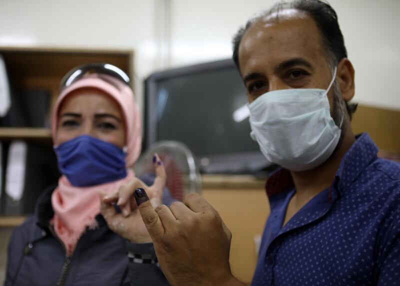 A man and a woman show their ink-stained fingers after voting at a polling station in Damascus. AFP