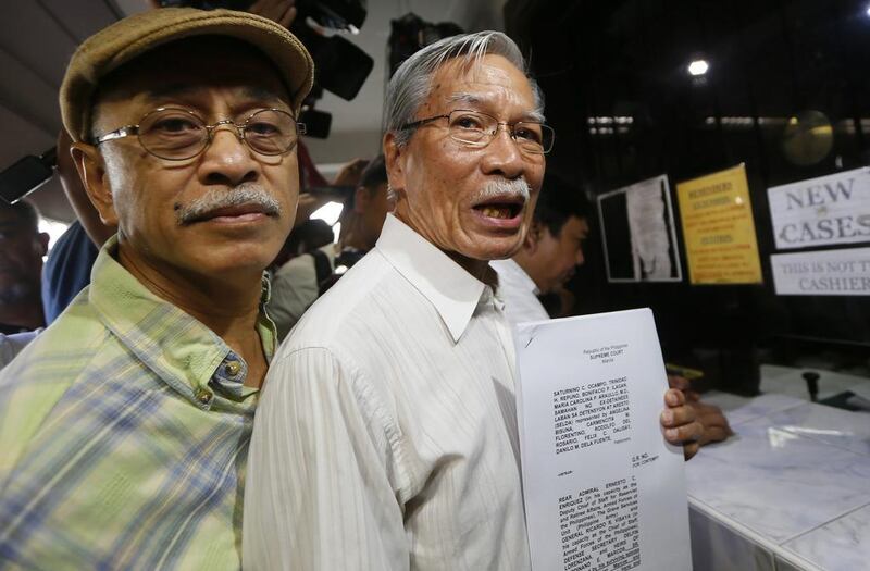 Activists Saturnino Ocampo, right, and Bonifacio Ilagan hold documents after filing a petition at the supreme court seeking to hold the Marcos’ heirs in contempt for carrying out his burial at the Heroes’ Cemetry even before the highest court had heard final appeals against it. Bullit Marquez / AP Photo