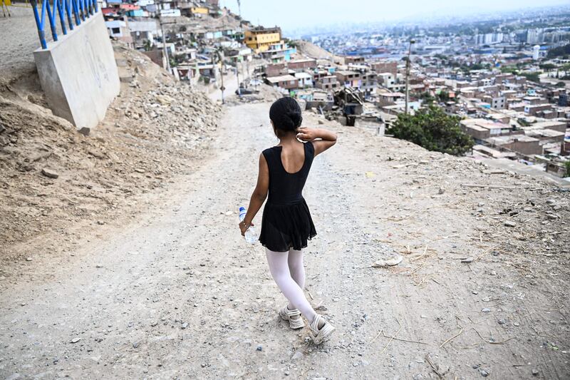 Ballet student Keith Chavez (12) goes down the hill after performing at the San Genaro neighborhood in the Chorrillos district, south of Lima, on April 1, 2023.  - At an arid and dry hill in Lima, a group of girls wearing leotards stand on their toes in a rocky and dusty road.  Hardly any of them will become a professional dancer, acknowledges without bitterness Maria del Carmen Silva, instructor of the ballet that finances itself from recycling in Peru.  (Photo by Ernesto BENAVIDES  /  AFP)