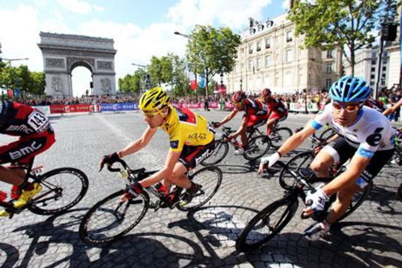 Cadel Evans, centre, turns the corner at L’arc de Triomphe during the 21st and final stage of Tour de France in Paris on Sunday.