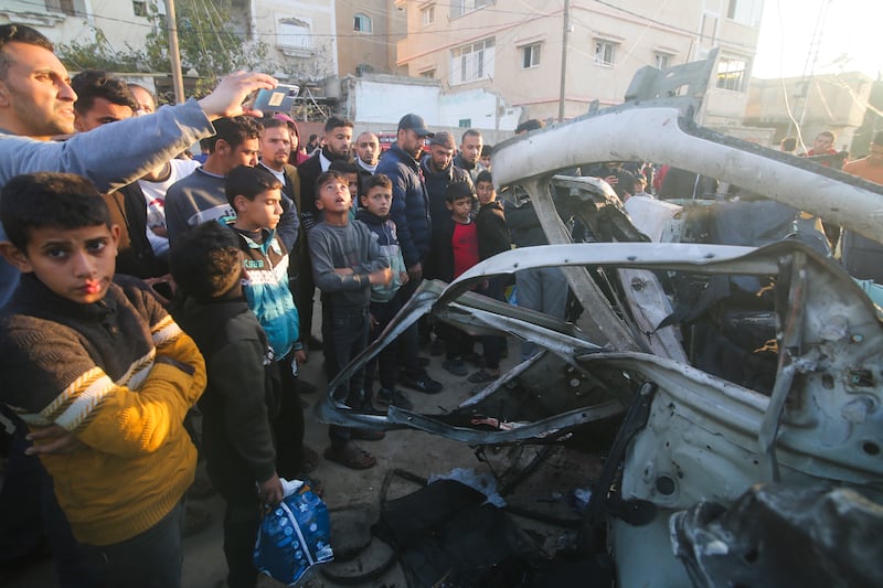 Palestinians gather around a Hamas police vehicle after it was struck by an Israeli air strike in Rafah. AP