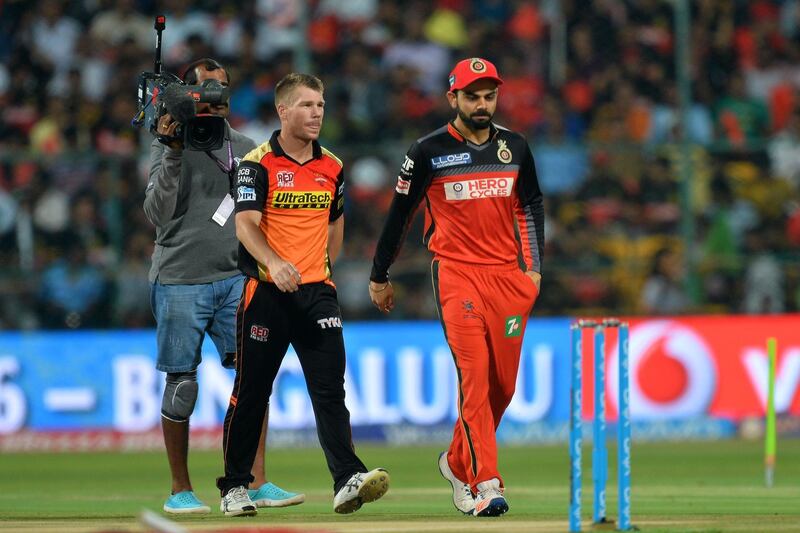 (FILES) In this file photo taken on May 29, 2016 Royal Challengers Bangalore captain, Virat Kohli (R) and his Sunrisers Hyderabad counterpart, David Warner walk back after the toss prior to the start of the final Twenty20 cricket match of the 2016 Indian Premier League (IPL) between Royal Challengers Bangalore and Sunrisers Hyderabad at The M. Chinnaswamy Stadium in Bangalore. Australia's Warner has warned against sledging Virat Kohli when India tour Australia this year, saying "trying to poke the bear" will only make the star batsman play better. As cricket slowly gets back into action after coronavirus suspensions, India are slated to tour Australia for four Test matches in December-January in what is set to be a highlight of the year. / AFP / Manjunath KIRAN
