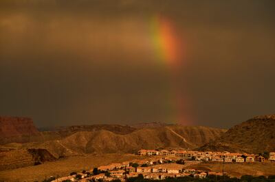 A rainbow shines behind homes on a hillside in St George, Utah, near the Colorado River. AFP