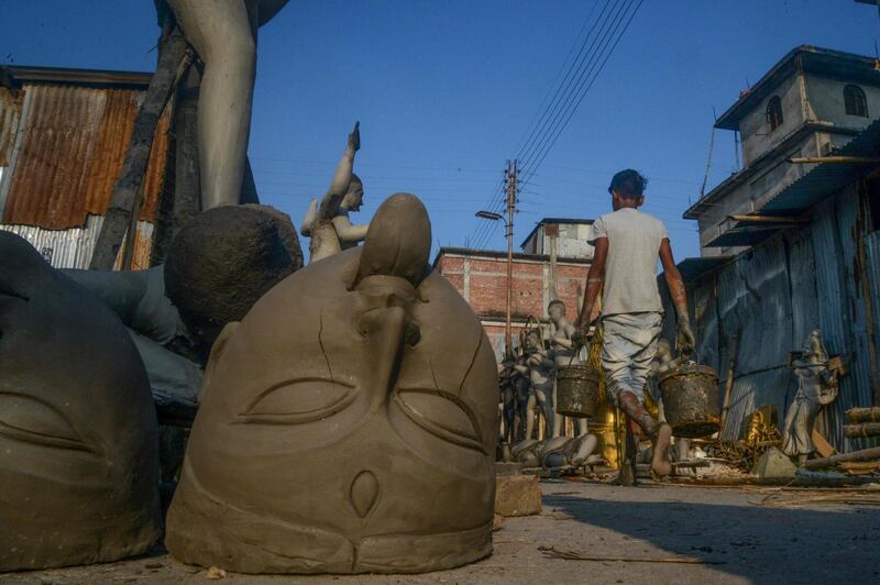 A worker walks near semi-finished clay idols of the Hindu goddess Kali in Siliguri on October 18, 2019. The worship of Hindu deity Kali takes place on October 27 in the eastern Indian states along with 'Diwali', the Festival of Lights, marking the victory of good over evil and commemorating the time when the Hindu god Lord Rama achieved victory over Ravana. AFP