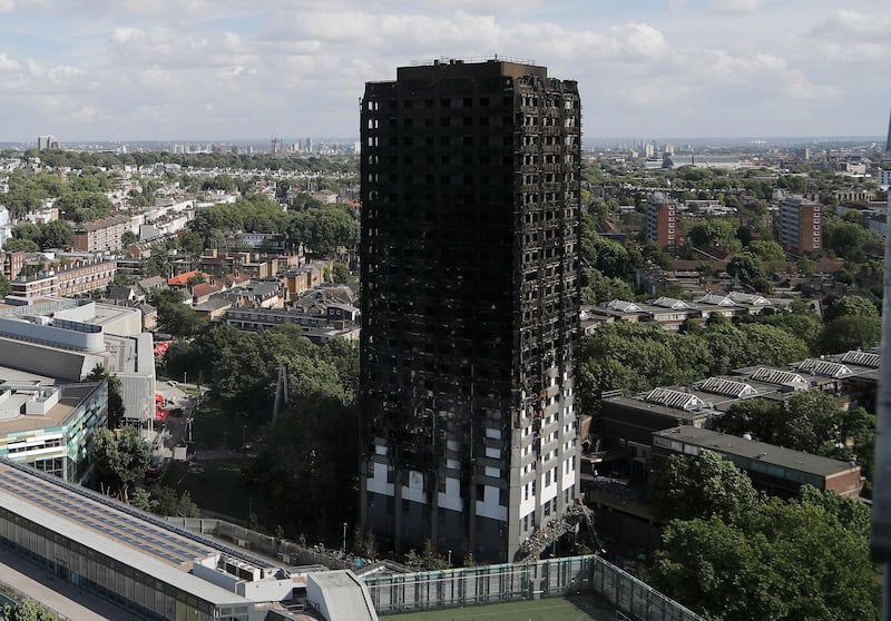 FILE - This is a Thursday, June 15, 2017 file photo of The scorched facade of the Grenfell Tower in London after a massive fire raced through the 24-storey high-rise apartment building in west London. British police said Tuesday, Sept. 19, 2017, the number of people who died in the Grenfell Tower fire in west London may be slightly lower than the 80 previously estimated.  (AP Photo/Frank Augstein/File)