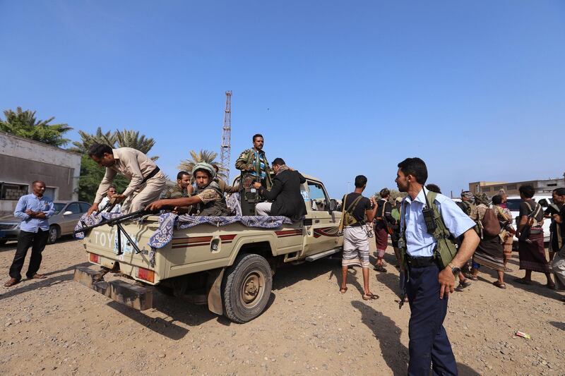 Houthi militants ride on the back of a truck as they withdraw from Hodeidah. Reuters