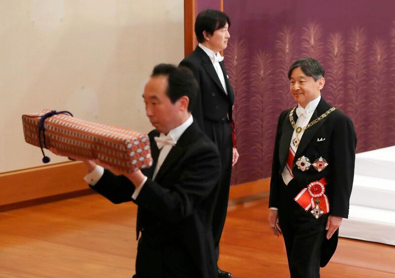 Japan's new Emperor Naruhito, right, leaves after the ceremony to receive the Imperial regalia of sword and jewel as proof of succession at Imperial Palace in Tokyo.  Standing at back is Crown Prince Akishino. AP