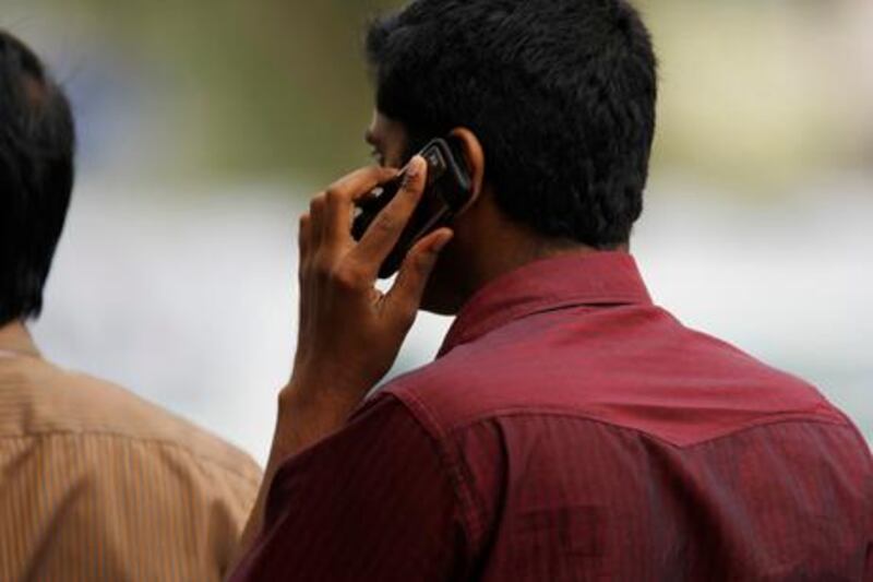 ABU DHABI, UNITED ARAB EMIRATES - January 2, 2010: 

A man speaks on a cell or mobile phone outside of Madinat Zayed Shopping centre in Abu Dhabi.

( Ryan Carter / The National )