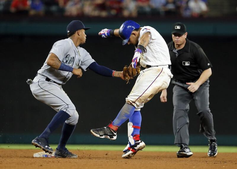 Seattle Mariners’ Ketel Marte (4) makes the tag on Texas Rangers’ Rougned Odor as second base umpire Carlos Torres, right, watches in the seventh inning of a baseball game, in Arlington, Texas. Odor was out on the play trying to stretch out a single. Tony Gutierrez / AP