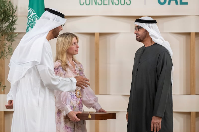 Sheikh Mohamed presents the First Class Order of Zayed II medal to Jennifer Jordan-Saifi, chief executive of Sustainable Markets Initiative, with Dr Sultan Al Jaber, Minister of Industry and Advanced Technology, who was also Cop28 President, looking on. Abdulla Al Neyadi / Presidential Court