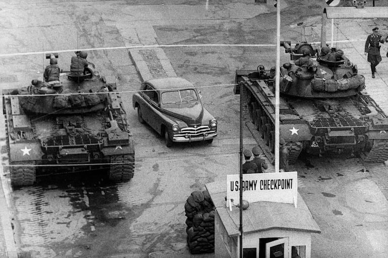 (FILES) - Picture taken in October 1961 shows a car between US tanks, driving across the famous border of the American sector in Berlin, at Checkpoint Charlie crossing point, the only one in the Berlin Wall between East (Soviet sector) and West Berlin (American sector), used only by diplomats and foreigners. The Berlin wall built by the East German government to seal off East Berlin from the part of the city occupied by the three main western powers (USA, Great Britain and France), and to prevent mass illegal emigration to the West. The wall, built along the border between German Democratic Republic (GDR) and Federal Republic of Germany, was the scene of the shooting of many East Germans who tried to escape from GDR. The two countries remained divided until November 1989 when the wall was unexpectedly opened following increased pressure for political reform in GDR.  AFP PHOTO
 *** Local Caption ***  571878-01-08.jpg