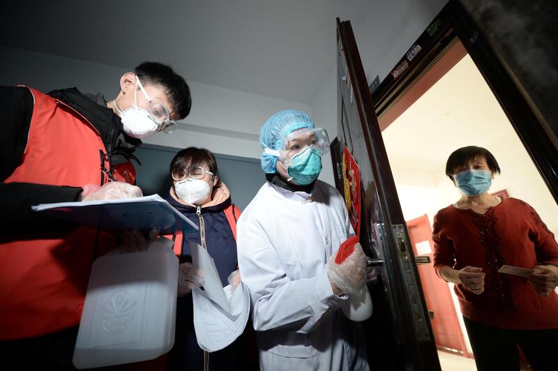 Community workers and medical staff visit a woman at her home as they conduct door-to-door search to inspect residents in Tianjin, China. Reuters