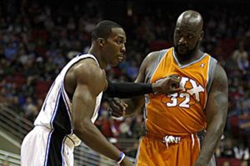 The Orlando Magic centre Dwight Howard, left, defends against the Phoenix Suns centre Shaquille O'Neal during their heated NBA match where the Magic win 111-99.