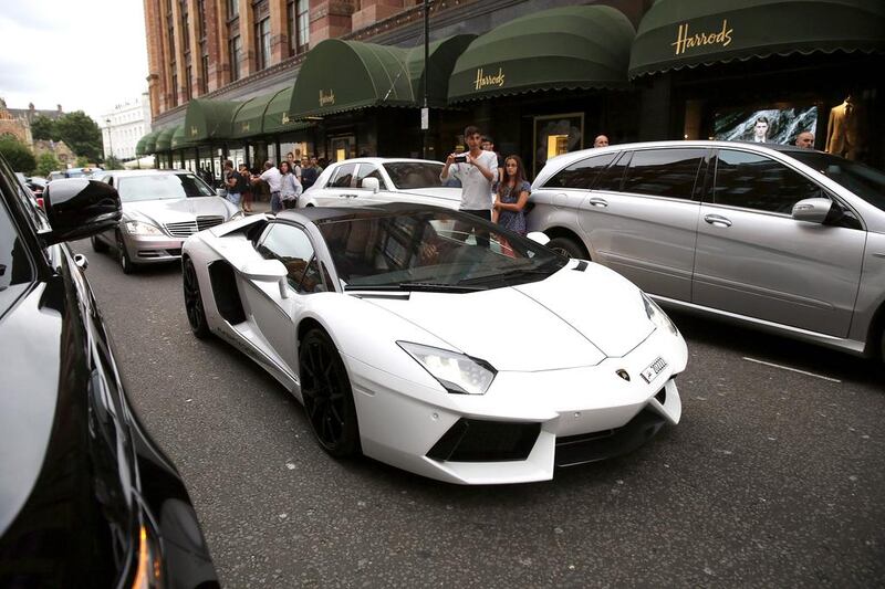 A Lamborghini Aventador drives through Knightsbridge. Cars enthusiasts show up with their cameras to film these supercars driven by Arab tourists. Dan Kitwood / Getty Images