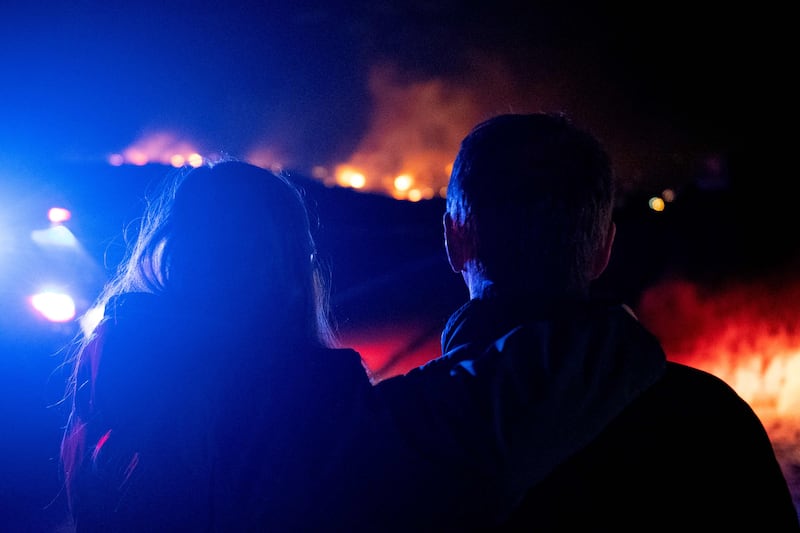 A couple watch flames engulf homes in Superior, Boulder County, an area that has been hit by drought, leaving vegetation tinder dry. AFP