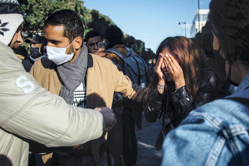 A young protester washes her eyes with Coca-Cola after being pepper sprayed by police in downtown Tunis Tuesday. Erin Clare Brown / The National