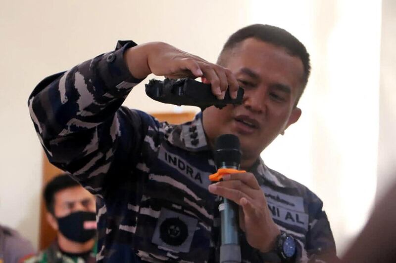 A naval officer shows parts of the torpedo system found in the search operation for the Navy's KRI Nanggala (402) submarine that went missing on April 21, at a press conference in Denpasar. AFP