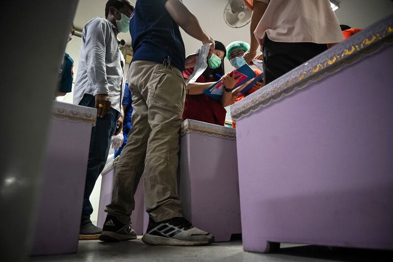 Rescue workers inspect coffins containing the bodies of victims at a hospital in Udon Thani, Thailand. Getty Images