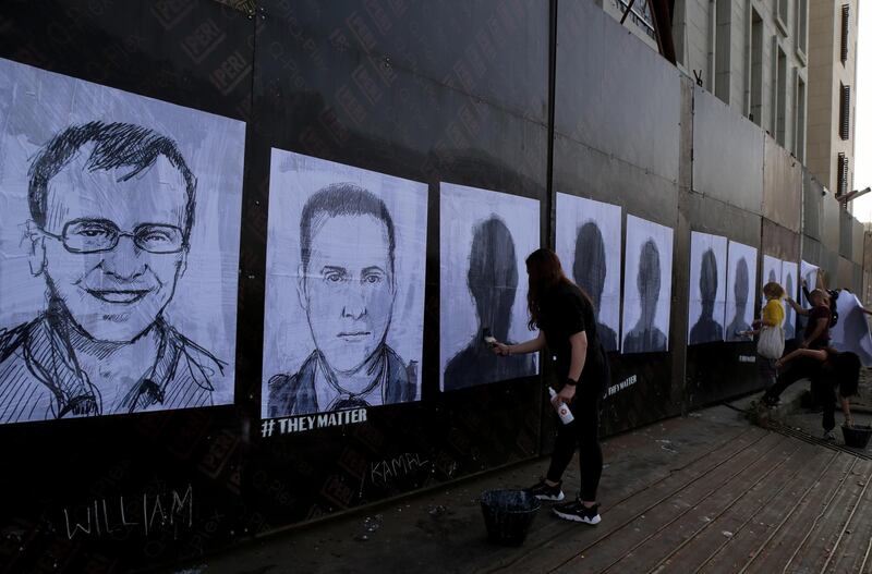 Activists hang portraits of the victims of the August 4 Beirut port explosion on a wall in the Lebanese capital. Artist Brady Black, in partnership with the Art of Change organisation, drew more than 200 caricatures of the victims. EPA