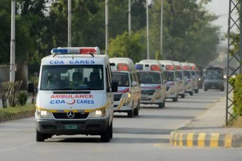 Pakistani police escort ambulances carrying the coffins of foreign tourists as they come out from Chaklala air base in Rawalpindi.