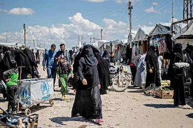 Women displaced from Syria's north-eastern Deir Ezzor province walk in a market inside Al Hol camp. AFP