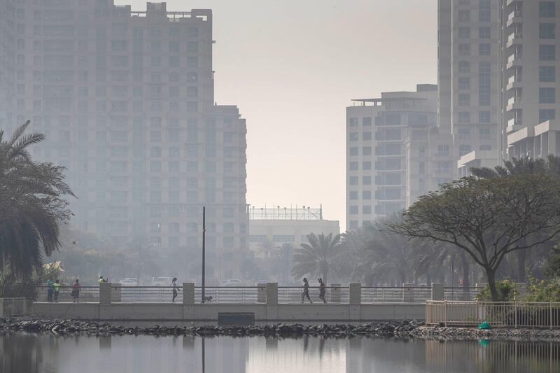 DUBAI, UNITED ARAB EMIRATES. 02 APRIL 2020. Weather picture during the time of the COVID-19 Stay At Home campaign in Dubai. Residents of The Greens walk along the lakes that are a main feature of the neighnourhood. (Photo: Antonie Robertson/The National) Journalist: Standalone. Section: National.