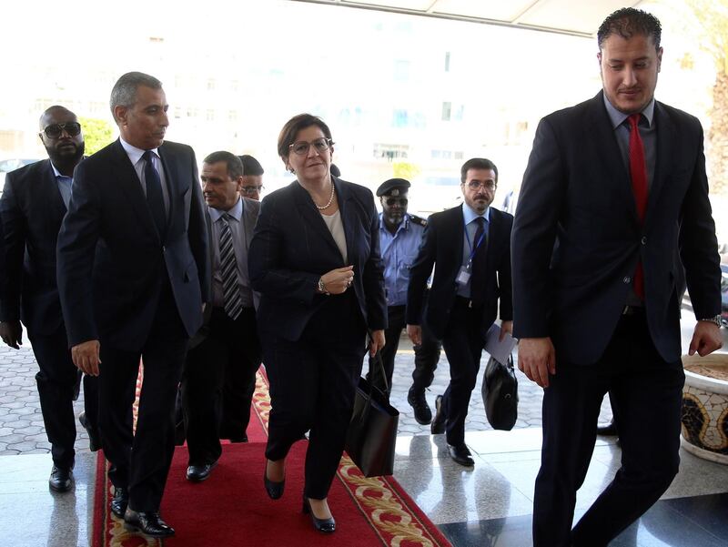 Italian Defence Minister Elisabetta Trenta (C) arrives to the office of Libya's unity government Prime Minister for a meeting in the capital Tripoli on July 24, 2018.  Trenta travelled to Libya today to reaffirm Rome's support for Libyan national reconciliation and Tripoli's efforts to curb the flow of migrants. / AFP / str
