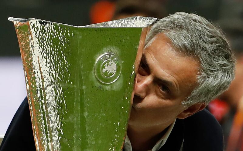 (FILES) This file photo taken on May 24, 2017 shows Manchester United's Portuguese manager Jose Mourinho kissing the trophy after the UEFA Europa League final football match Ajax Amsterdam v Manchester United on May 24, 2017 at the Friends Arena in Solna outside Stockholm.
Manchester United narrowly pipped Real Madrid to remain the world's top-earning football club as Premier League clubs underlined their growing financial clout, a closely watched survey said on January 23, 2018. It is the 10th time United have topped Deloitte's Football Money League, with a revenue in 2016/17 of 676 million euros (£581m) -- just 1.7 million euros ahead of the Spanish giants. United’s UEFA Europa League victory was critical to their financial performance. / AFP PHOTO / Odd ANDERSEN