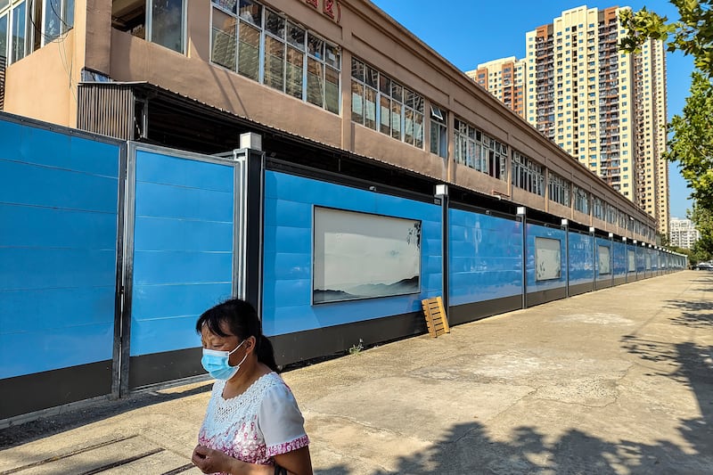 A woman walks past a closed market in Wuhan, the central Chinese city where Covid-19 was first identified. Getty