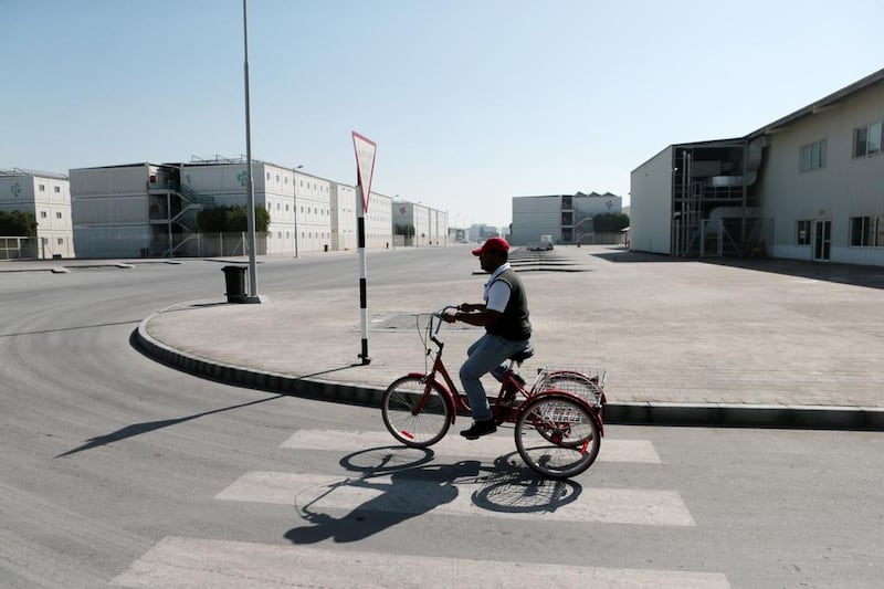 A man rides a bicycle through the accommodation village. Christopher Pike / The National