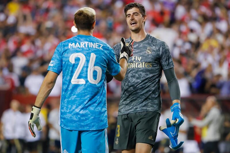Real Madrid goalkeeper Thibaut Courtois greets Arsenal goalkeeper Emiliano Martinez at the conclusion of the second half. EPA