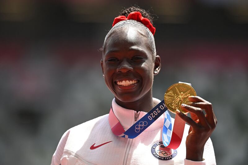 Athing Mu, of the United States, celebrates on the podium with the gold medal after competing in the women's 800m final.